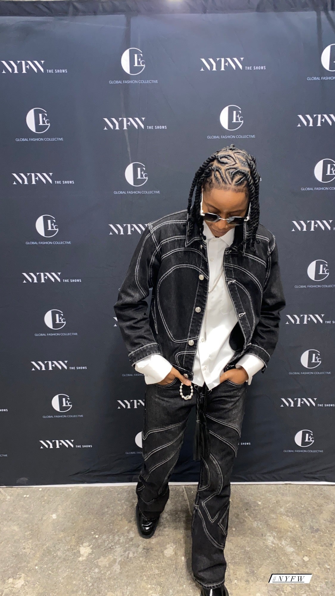 Person wearing the black Midnight Voyager denim set at a New York Fashion Week step-and-repeat event.