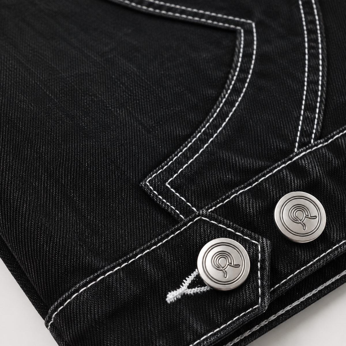 Close up of the custom 18 mm gunmetal R-logo button on the Midnight Voyager Denim Jacket.