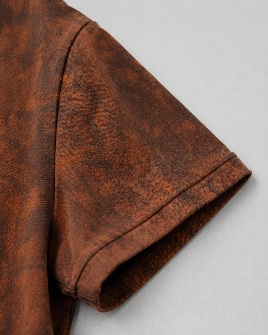 Close-up of the exposed overlock seam construction on the reversible Sunfaded T-Shirt. showing the sleeve cuff and shoulder seam.