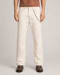 Model wearing the Limestone Voyager Denim Pant, front view, showing its slim fit and controlled flared silhouette.