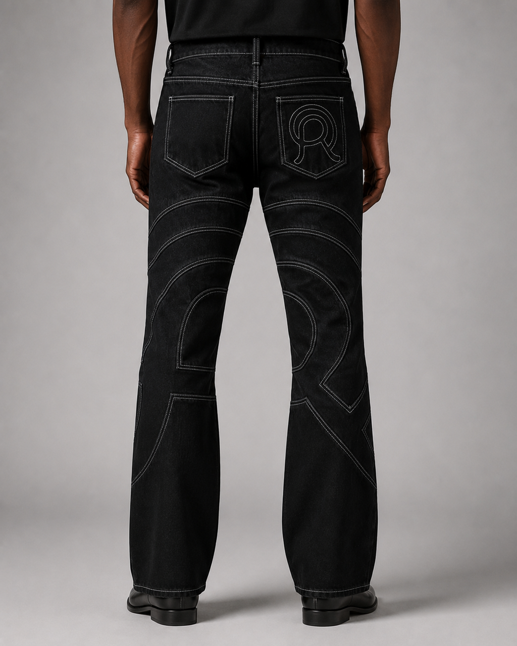 Model wearing the Midnight Voyager Denim Pant, back view, with curved light grey contrast topstitching.
