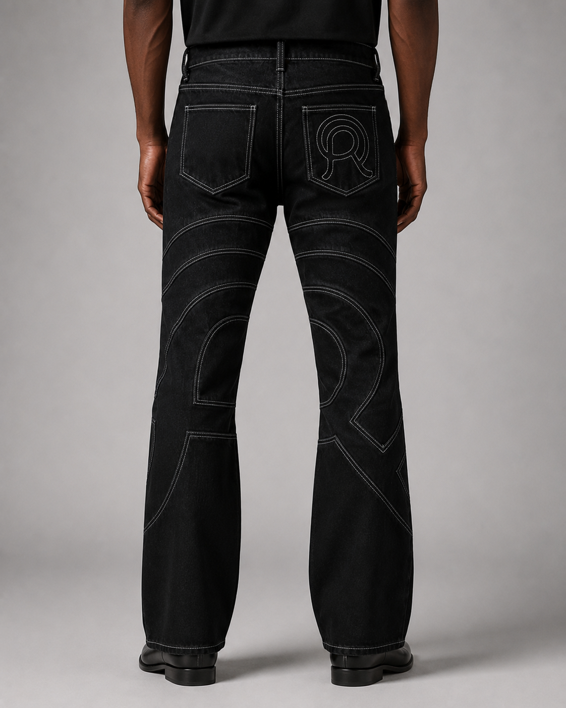 Model wearing the Midnight Voyager Denim Pant, back view, with curved light grey contrast topstitching.